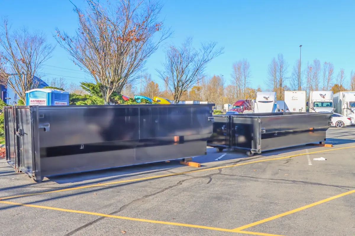 Professional dumpster rental service with roll-off container on residential driveway in Long View